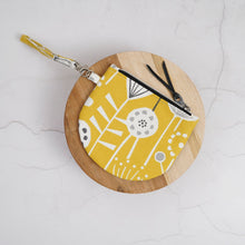 Load image into Gallery viewer, Round wooden pouch with yellow fabric interior on a light gray background Brooke Wristlet Sewing Pattern PDF