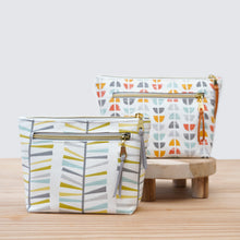 Load image into Gallery viewer, Two patterned pouches on a wooden surface with a light background pfd sewing pattern Molko Studios