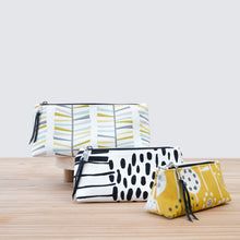Load image into Gallery viewer, Three patterned pouches on a wooden surface with a light gray background