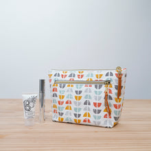 Load image into Gallery viewer, Patterned makeup bag with a small bottle and tube on a wooden surface Imogen Zipper Pouch PDF Sewing Pattern