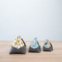 Load image into Gallery viewer, Three fabric pouches with geometric patterns on a wooden surface and light blue background Nora Zipper Pouch Pattern PDF