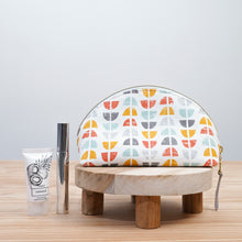 Load image into Gallery viewer, Patterned cosmetic bag on a wooden stool with skincare products on a light background Seren Dumpling Sewing Pattern PDF