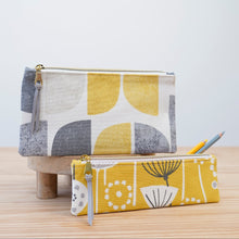 Load image into Gallery viewer, Two fabric pouches with geometric patterns on a wooden surface. Tasnim Pencil Case Sewing Pattern PDF