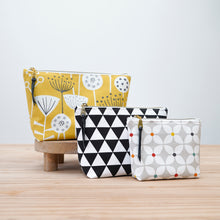 Load image into Gallery viewer, Three patterned pouches on a wooden surface with a light gray background Verity Zipper Pouch Sewing Pattern PDF