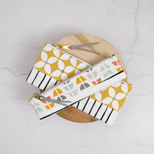 Load image into Gallery viewer, Two patterned pouches on a wooden block with a light gray background Athena Pencil Case Sewing Pattern PDF
