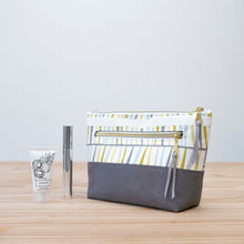Load image into Gallery viewer, Striped pouch with gray base on a wooden surface Ayla Zipper Pouch Sewing Pattern PDF
