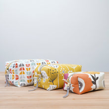 Load image into Gallery viewer, Three fabric pouches with colorful designs on a wooden surface and light gray background Demi Boxy Bag Sewing Pattern PDF
