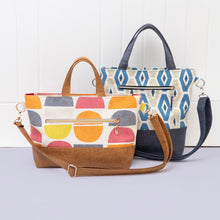 Load image into Gallery viewer, Two handbags on a light gray surface with a white wooden panel background Eden Zipped Tote Sewing Bag Pattern PDF
