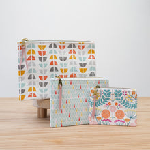 Load image into Gallery viewer, Three patterned pouches on a wooden surface with a light background Esmee Zipper Pouch Sewing Pattern PDF
