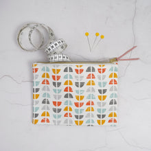 Load image into Gallery viewer, Fabric pouch with geometric pattern, measuring tape, and pins on a light gray background Esmee Zipper Pouch Sewing Pattern PDF
