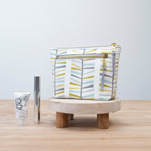 Load image into Gallery viewer, Patterned toiletry bag on a wooden stool with skincare products on a light background Imogen Zipper Pouch PDF Sewing Pattern 
