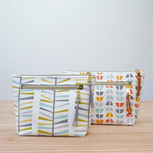 Load image into Gallery viewer, Two patterned pouches on a wooden surface with a light gray background Imogen Zipper Pouch PDF Sewing Pattern 

