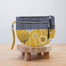 Load image into Gallery viewer, Fabric pouch with floral design on a wooden stand against a light  background Lexi Wristlet Sewing Pattern PDF
