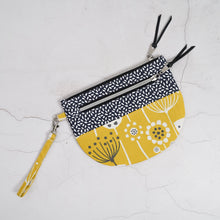 Load image into Gallery viewer, Two fabric pouches with zipper, one black and white patterned and the other yellow with floral design, on a light gray background. Lexi Wristlet Sewing Pattern PDF
