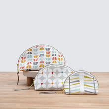 Load image into Gallery viewer, Three patterned cosmetic bags on a wooden surface with a light background
