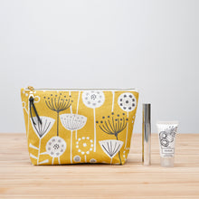 Load image into Gallery viewer, Yellow floral-patterned makeup bag with a small bottle and tube on a wooden surface Verity Zipper Pouch Sewing Pattern PDF

