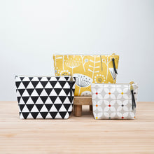 Load image into Gallery viewer, Three patterned pouches on a wooden surface with a light gray background Verity Zipper Pouch Sewing Pattern PDF
